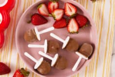 fudge pops with strawberries on pink plate.