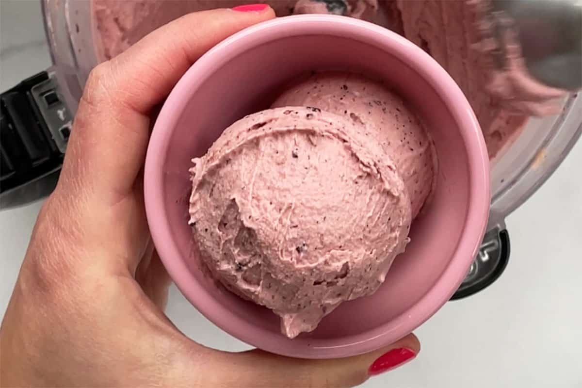 scoops of blueberry ice cream in pink bowl.