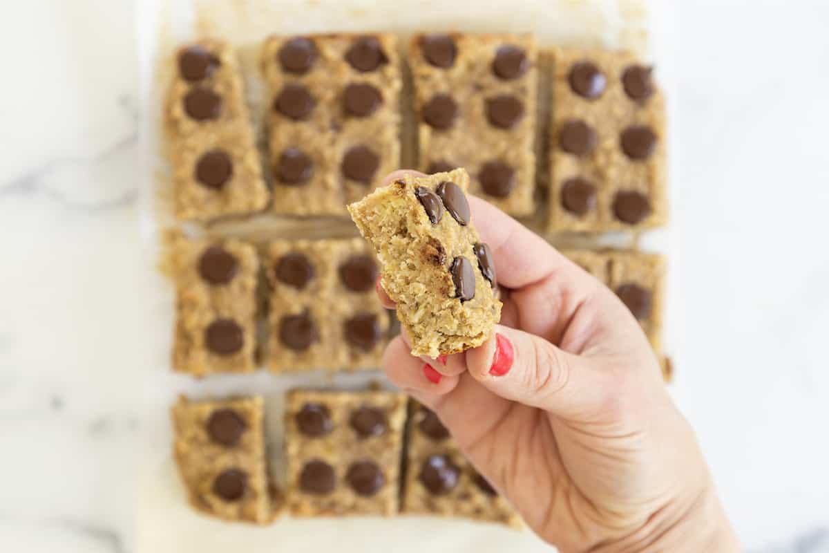 Banana oatmeal bars cut into rectangles with hand holding one.
