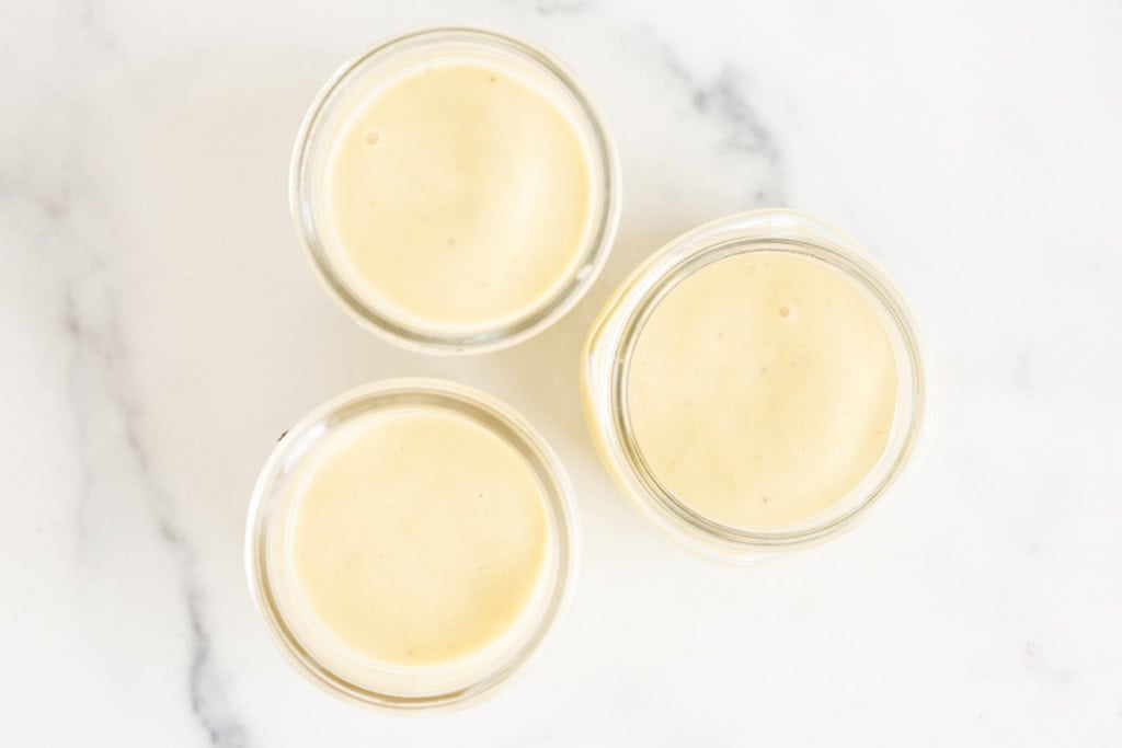 Banana pudding in three glass jars.