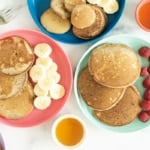 buckwheat pancakes on three plates with sides.