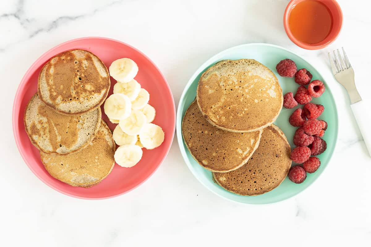 buckwheat pancakes on two plates with sides.