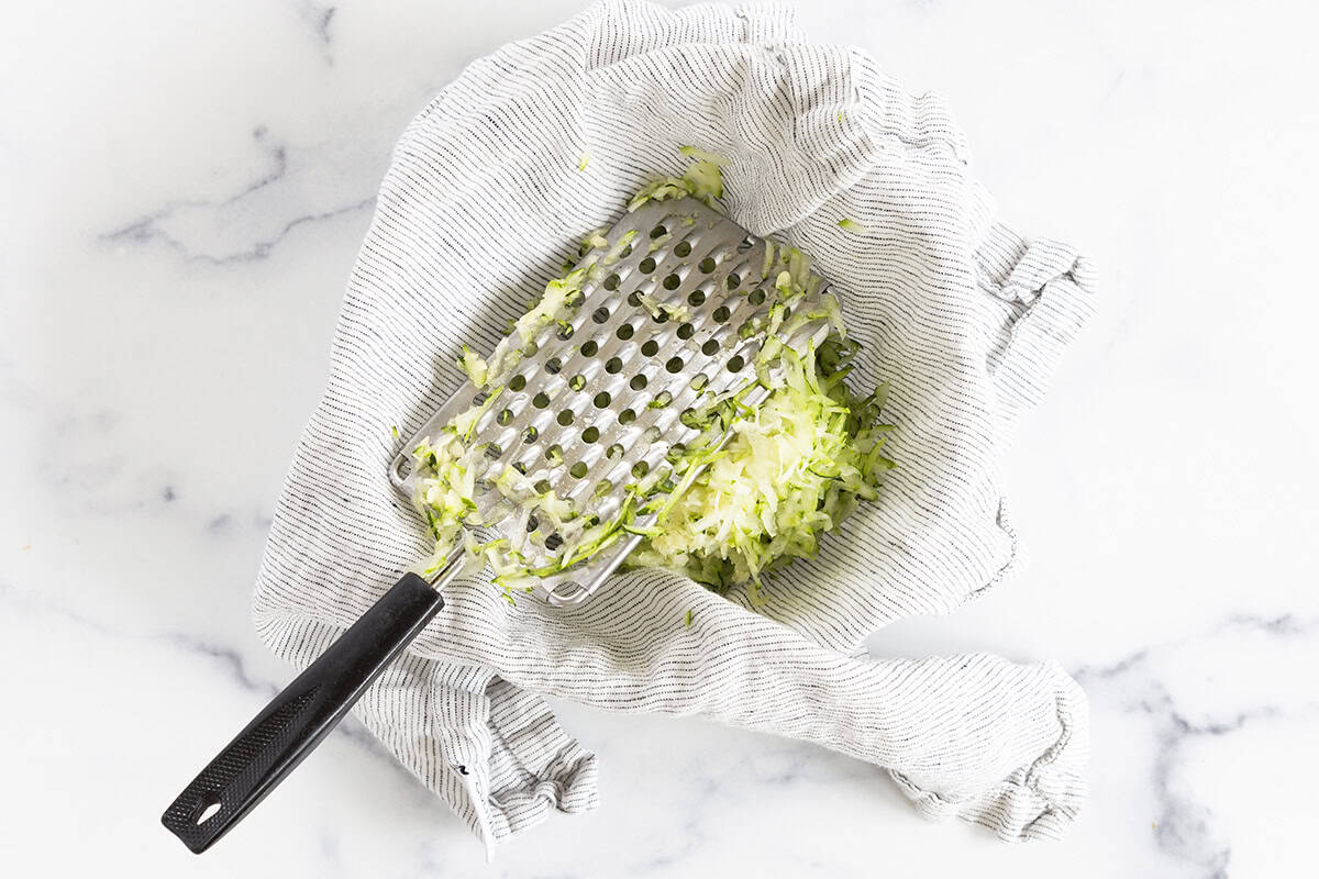 Grating zucchini into a towel for zucchini tots. 