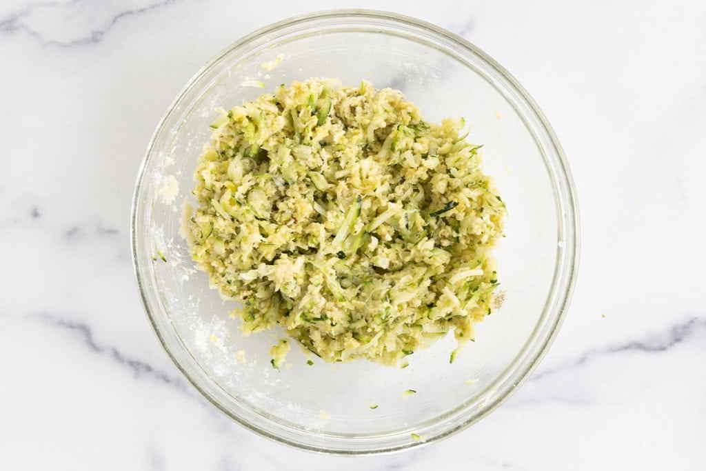 Mixture for zucchini tots in glass bowl.