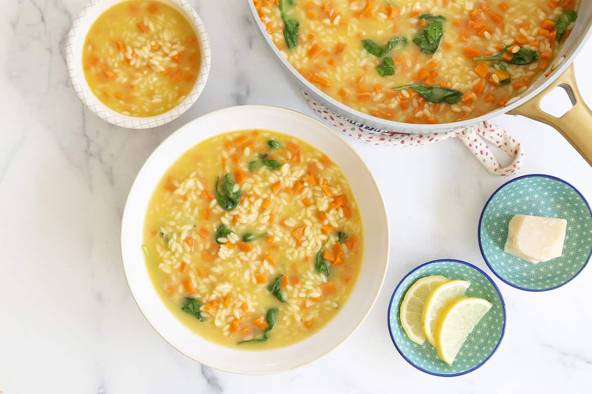 Orzo soup in bowls and pan. 