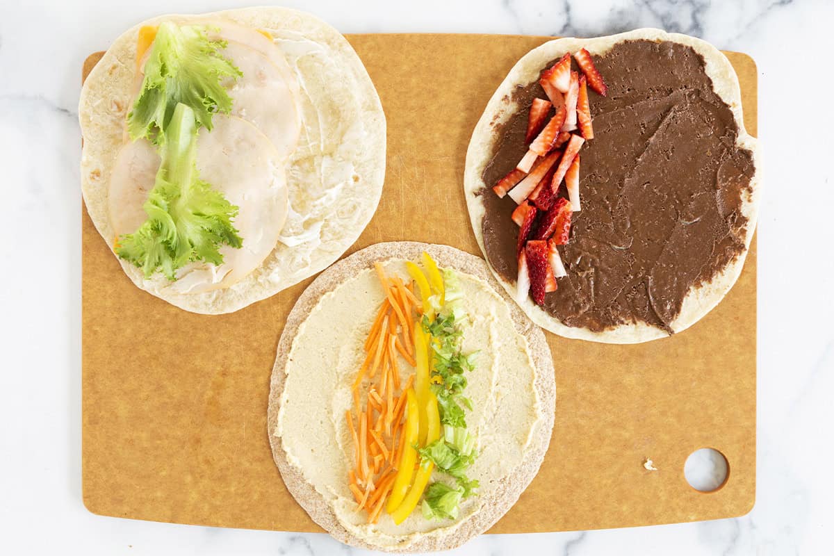 Tortilla with filling on them for pinwheel sandwiches.