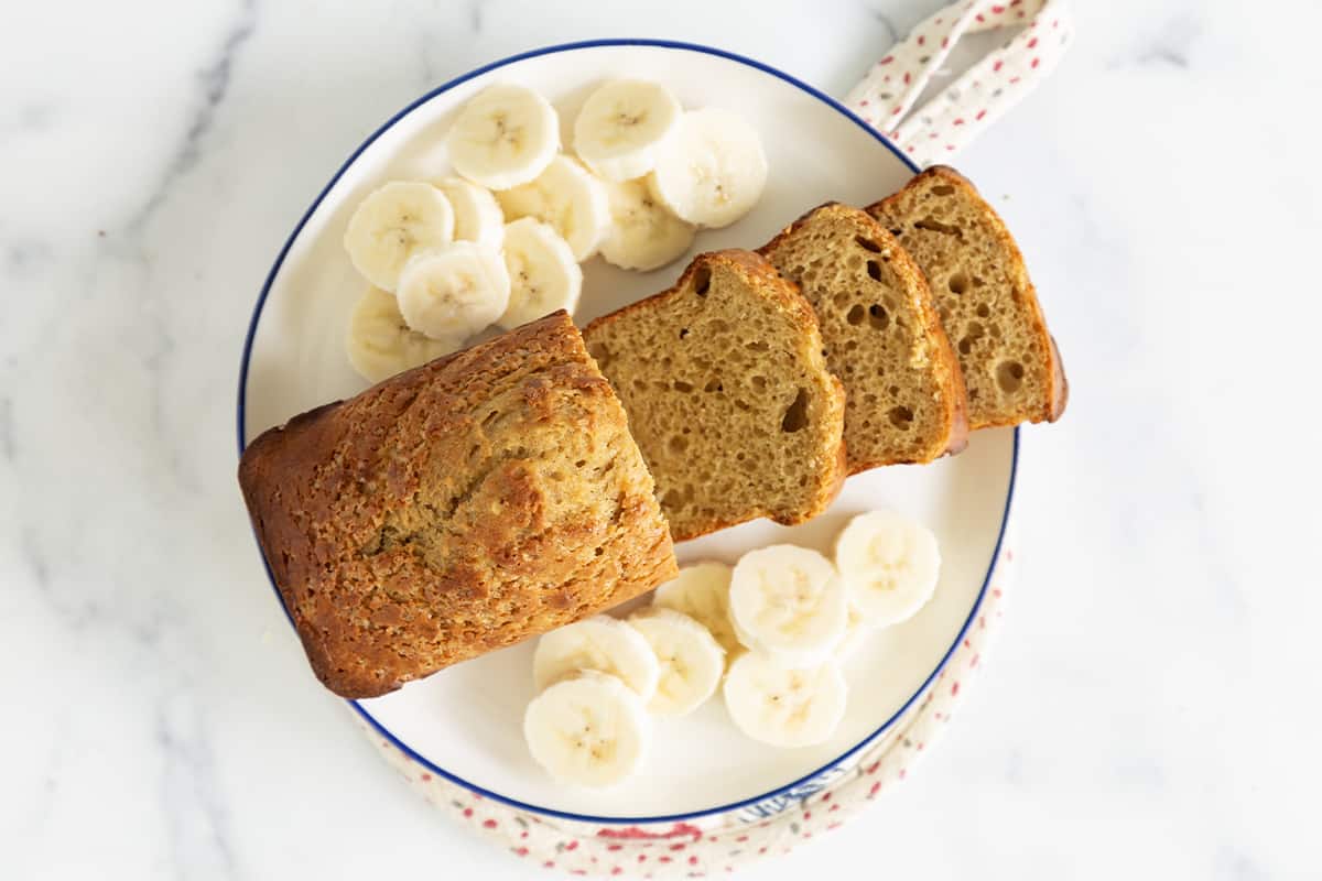 Protein banana bread on plate with banana slices.