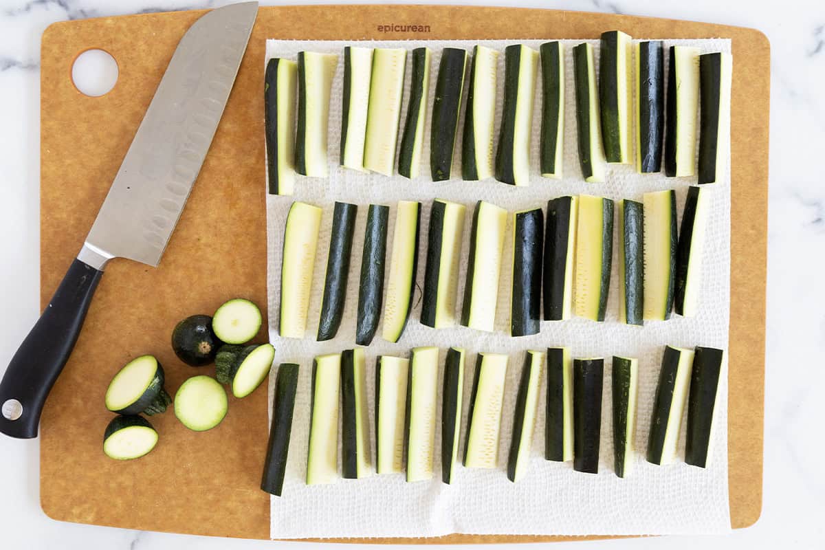 Cutting zucchini on cutting board for zucchini fries.