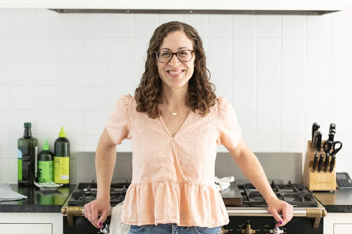 Amy Palanjian in kitchen leaning against stove.
