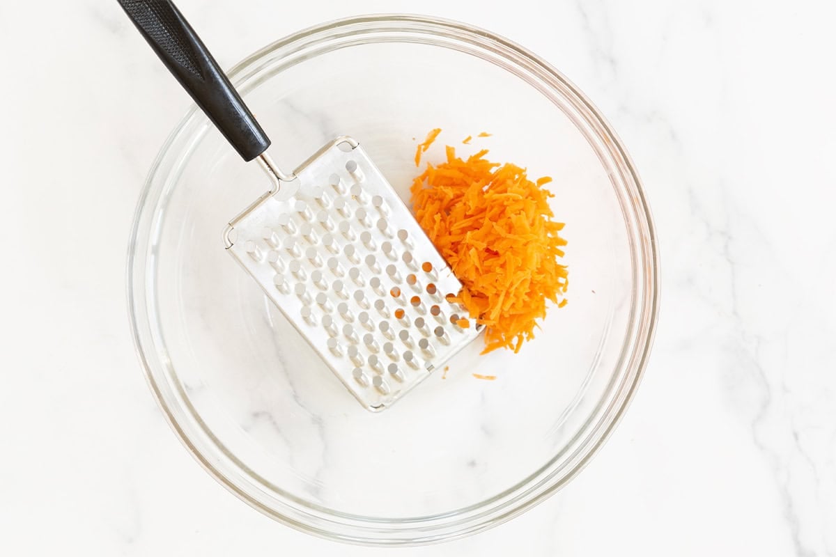 Shredded carrot in glass bowl for chicken meatballs.