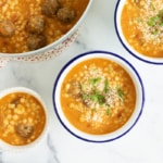 Meatball soup in various bowls and pot.