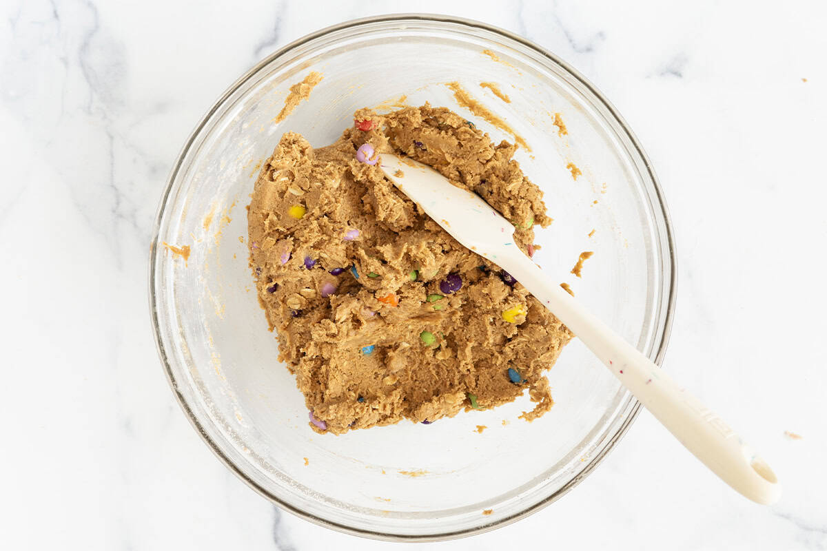 Dough for monster cookies in glass bowl.