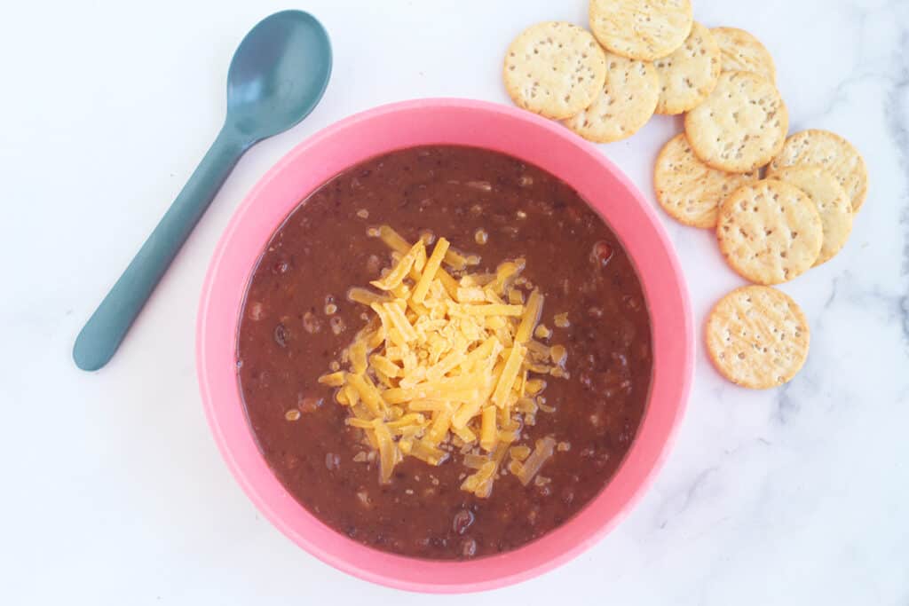 slow cooker black bean soup in pink bowls.