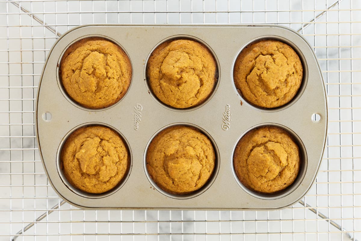 Pumpkin muffins in muffin pan after baking.