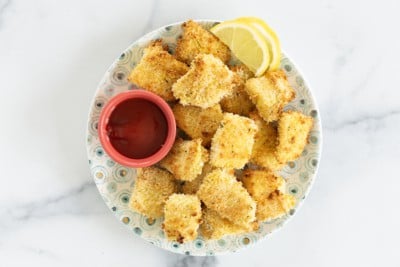 Fish nuggets on plate with dipping sauce.