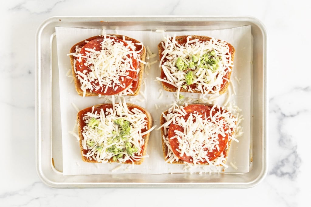 Adding toppings to toast for pizza toast.