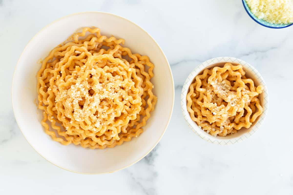 Two bowls with red pepper pasta.