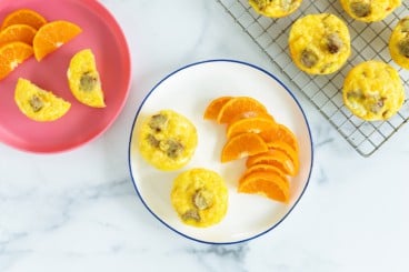 Sausage egg muffins on plates with sides.