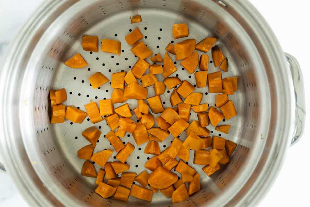 Sweet potatoes steaming in pan for sweet potato tots.