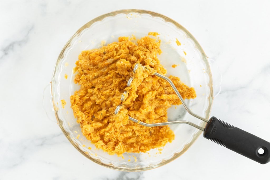 Mashing together ingredients for sweet potato tots.