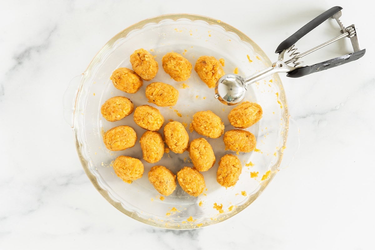 Forming sweet potato tots with an ice cream scoop.