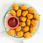 Sweet potato tots on plate with sauce.