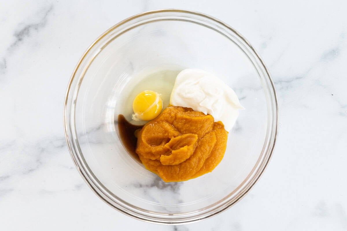 Ingredients for pumpkin muffins in glass bowl.