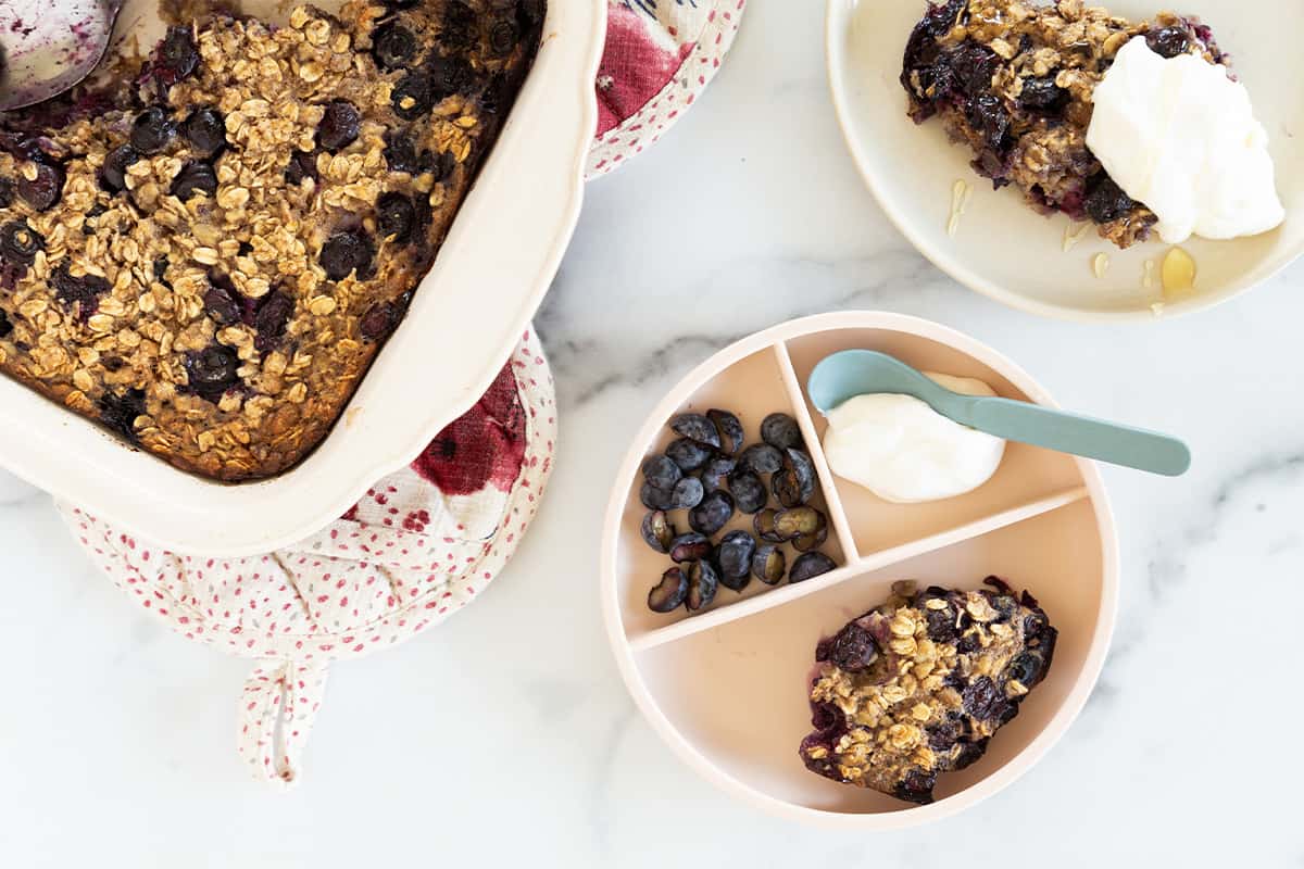 Blueberry baked oatmeal on two plates and in pan.