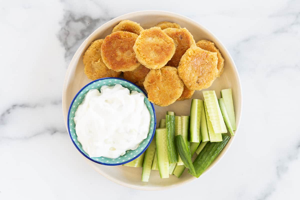 Chickpea fritters with side and dip on plate. 