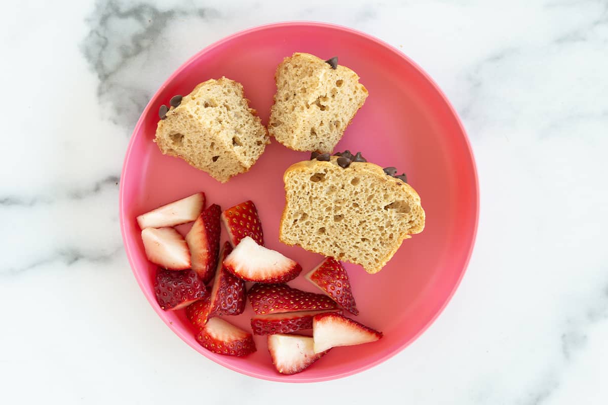 Banana protein muffins on pink kids plate.