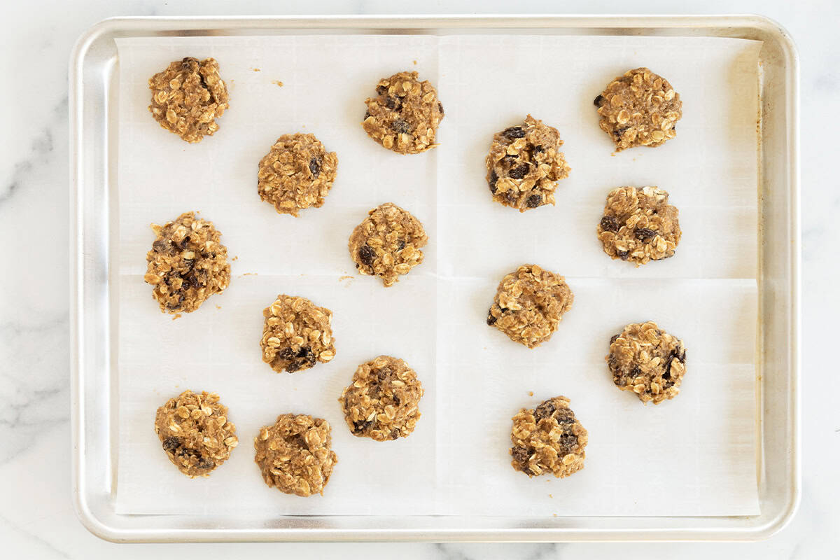 Oatmeal raisin cookies on baking sheet before baking.