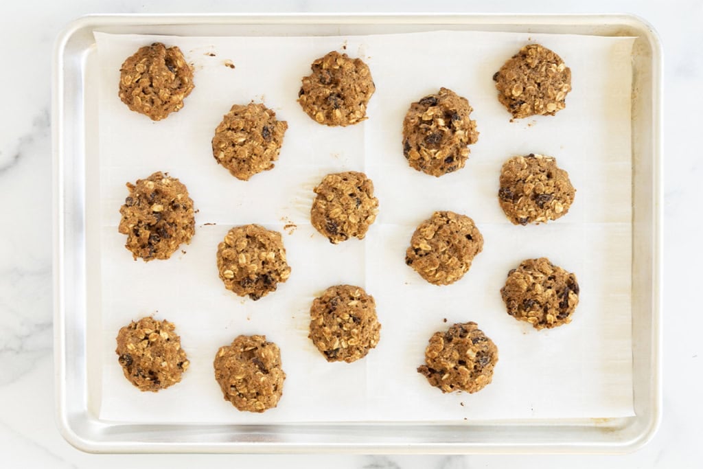 Oatmeal raisin cookies on baking sheet after baking.