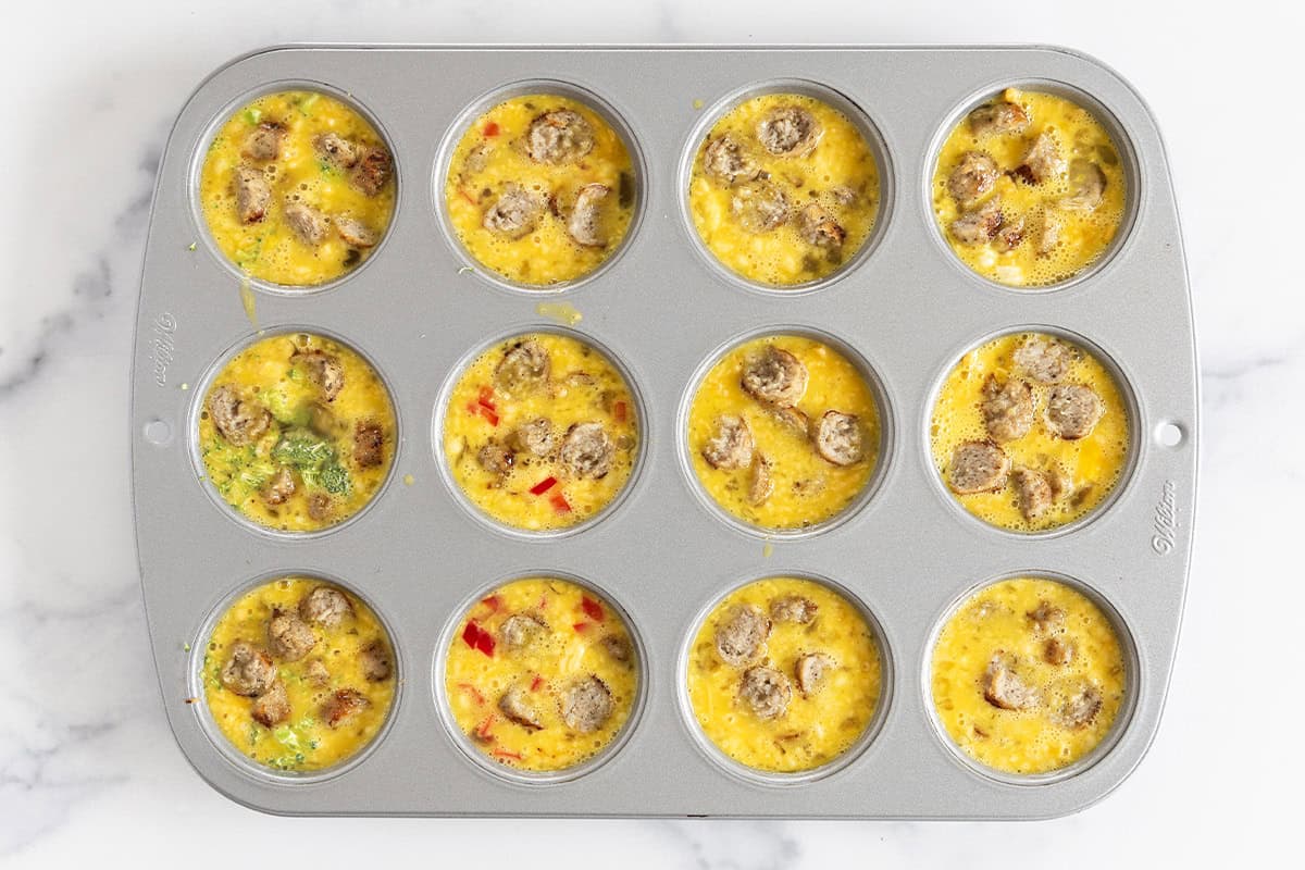 sausage egg muffins in muffin pan before baking.