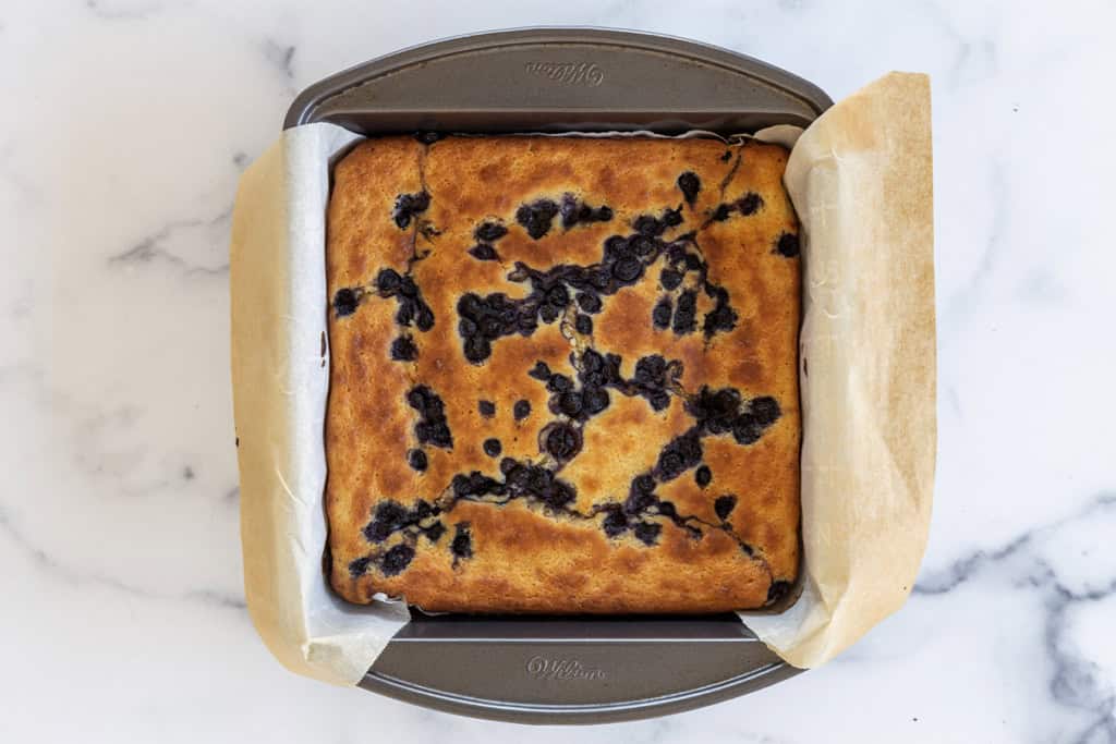 Blueberry yogurt cake in baking pan.