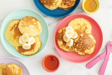 3 ingredient banana pancakes on three plates with sides.