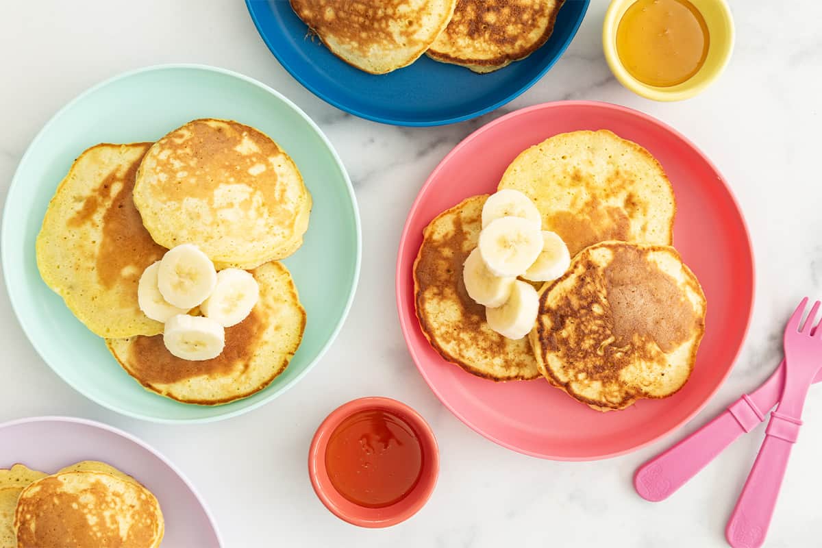 3 ingredient banana pancakes on three plates with sides.