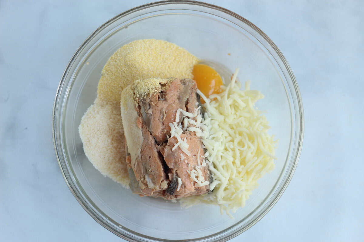 Ingredients for salmon cakes in glass bowl. 