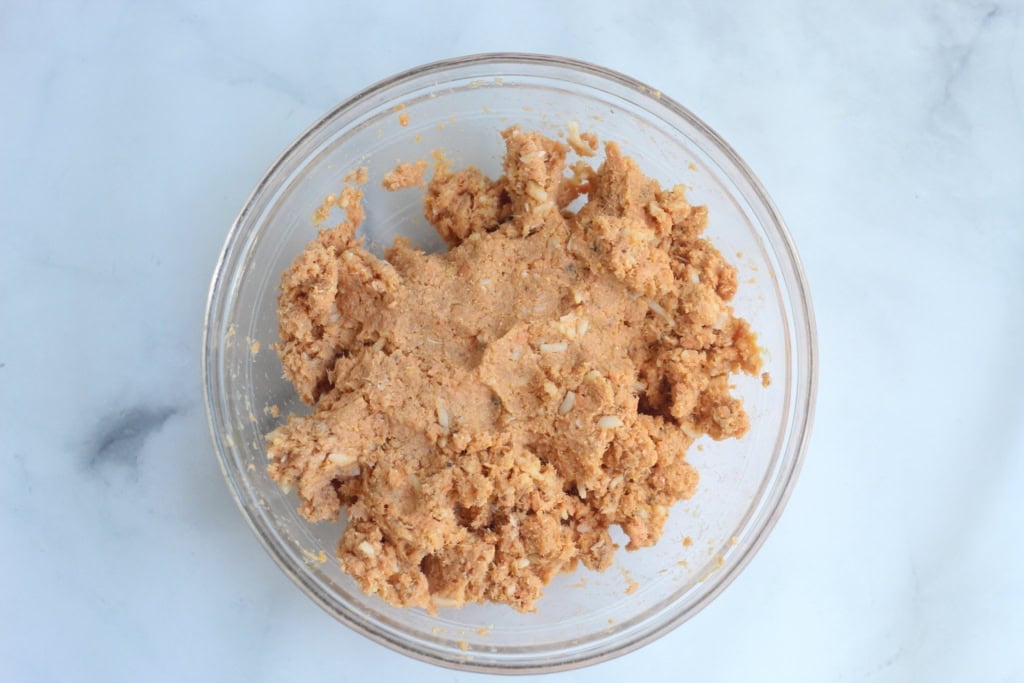 Mixture for salmon cakes in glass bowl.