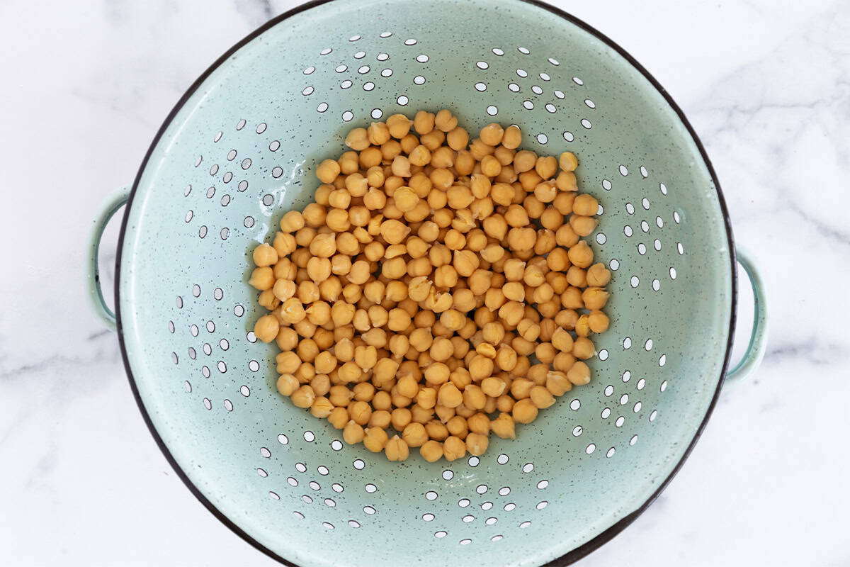 Chickpeas in strainer for chickpea fritters.