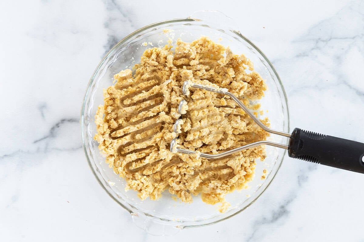 Mashing chickpea mixture for chickpea fritters.