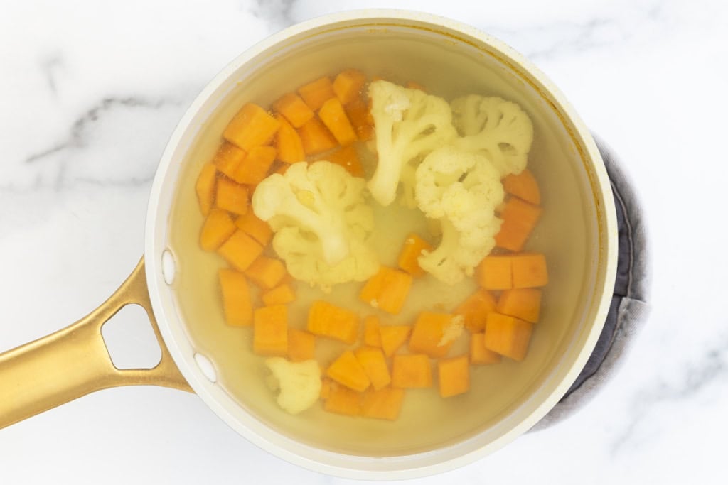 Boiling veggies in water for hidden veggie mac and cheese.