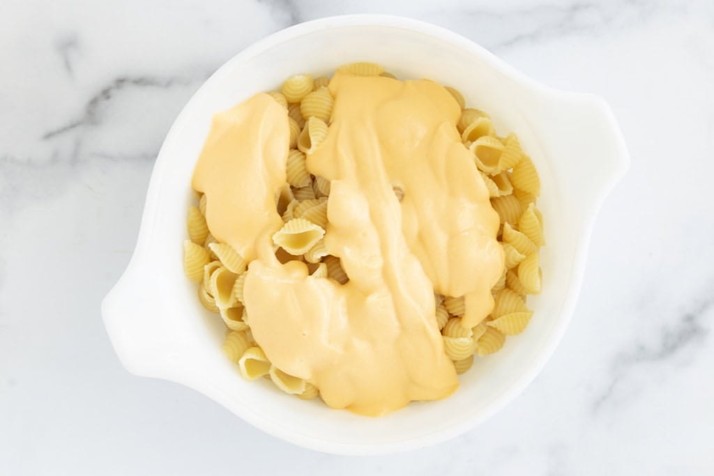 Mixing sauce with pasta for hidden veggie mac and cheese.