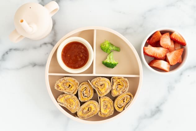 Taco roll ups on kids plate with sides.