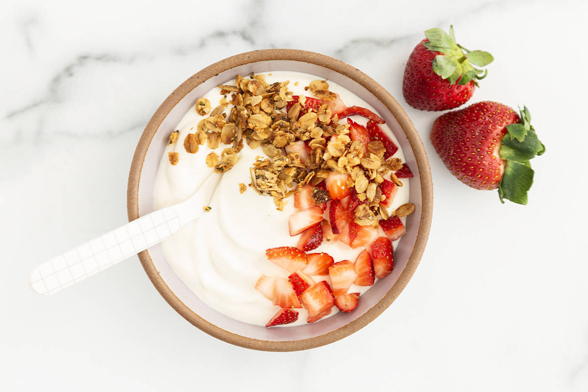 Vanilla yogurt in bowl with strawberries and yogurt.