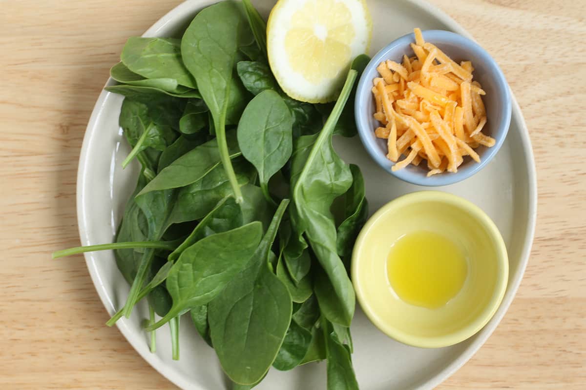 ingredients for cheesy spinach on plate.