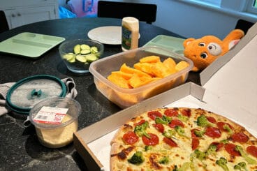 pizza box on counter with clutter.