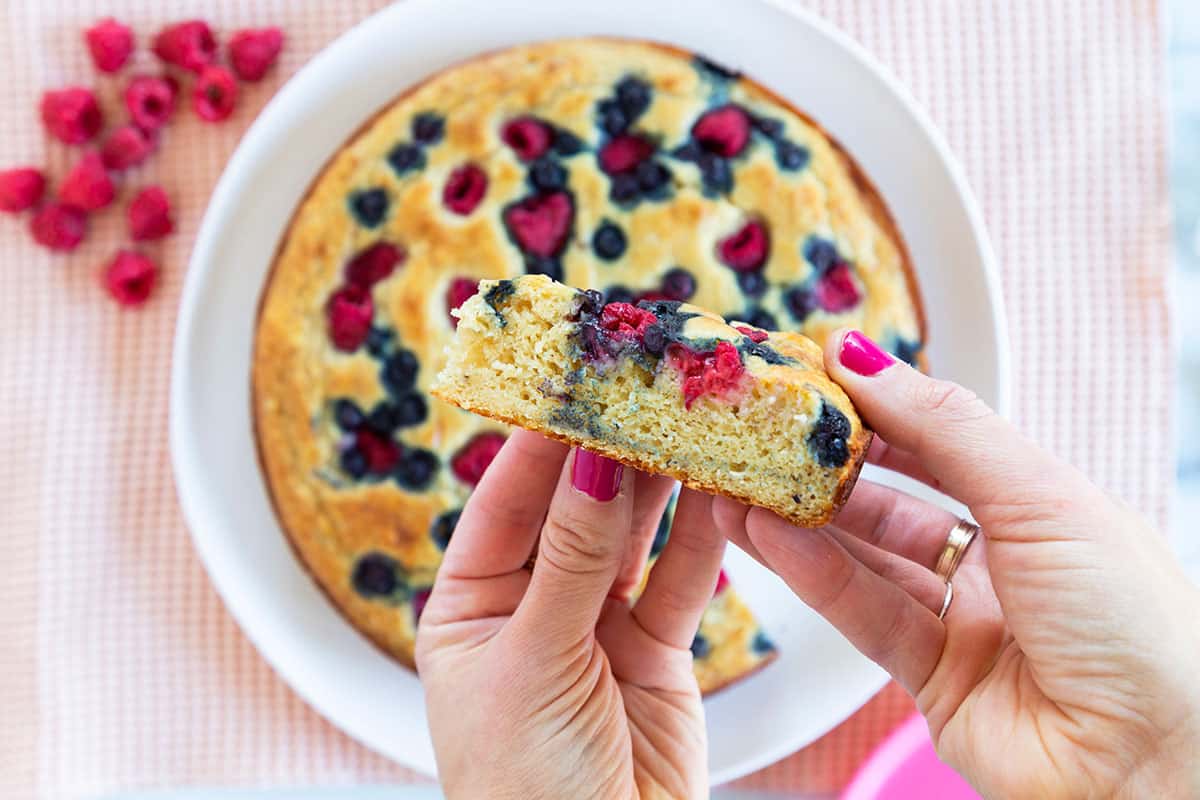slice of breakfast cake in hand with pink nails.