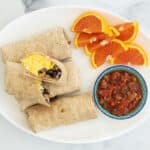 breakfast burritos on plate with salsa.