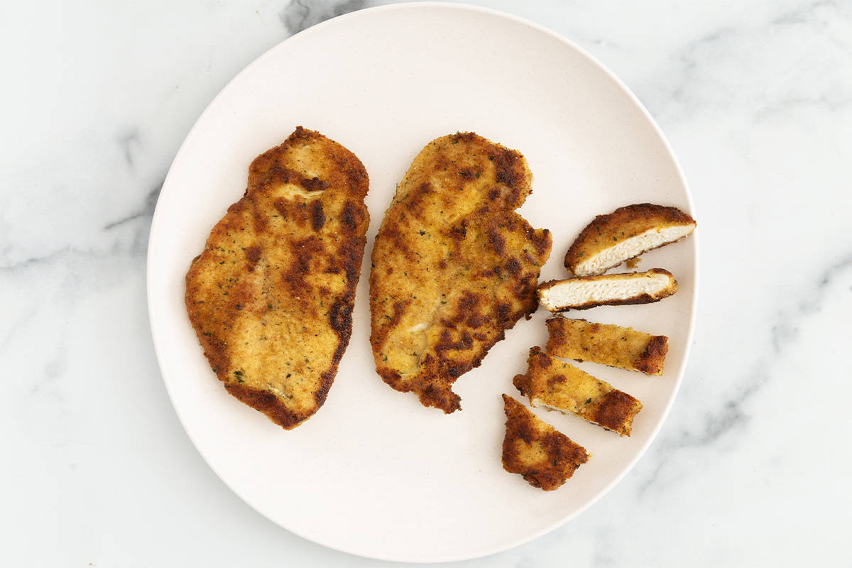 Easy Italian chicken cutlets on white plate.