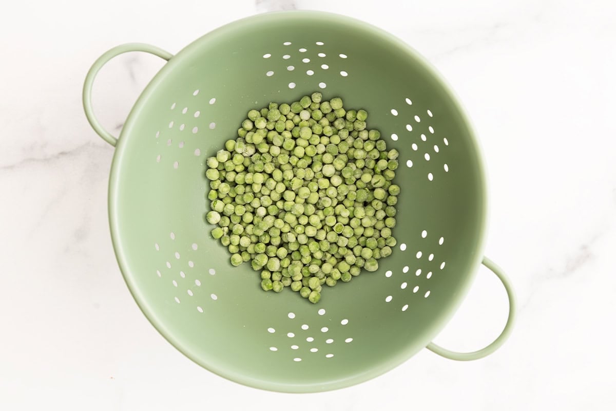 Peas in strainer for pesto pasta with peas. 